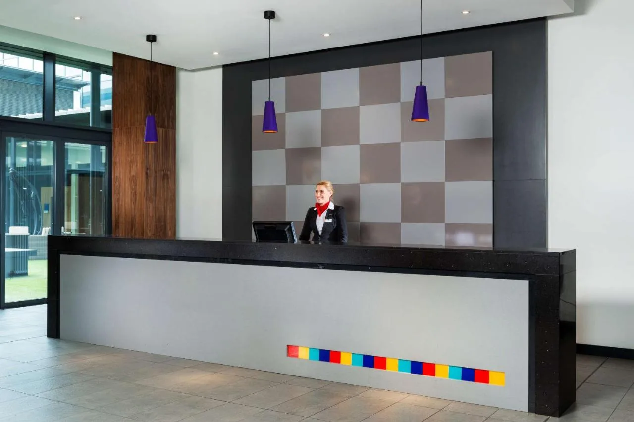 A man in a suit at the reception desk of Park Inn by Radisson Aberdeen