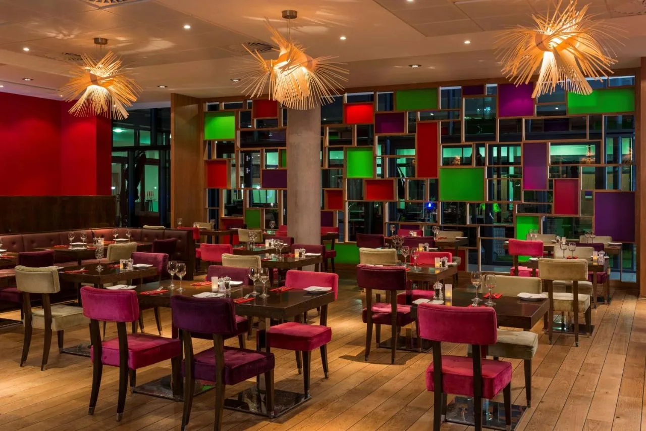 A restaurant with tables, chairs and bookshelves at the Aberdeen city centre hotel