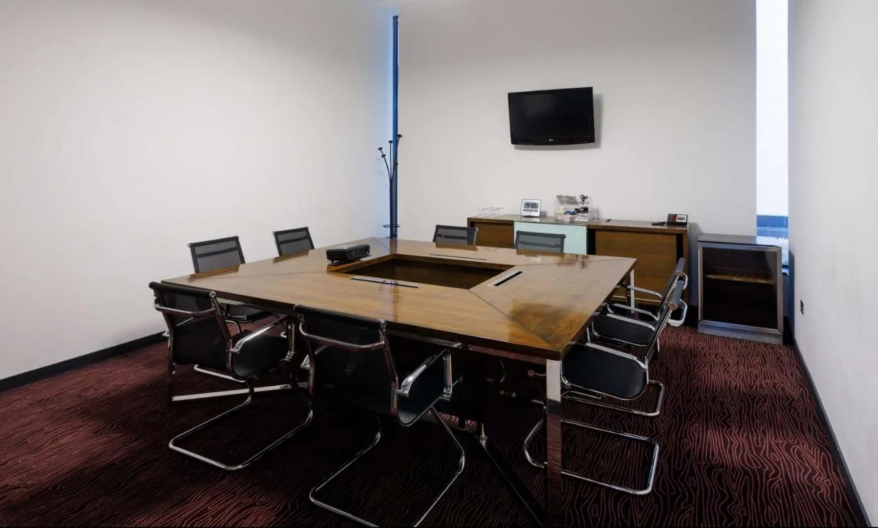 A conference room with a wooden table and chairs